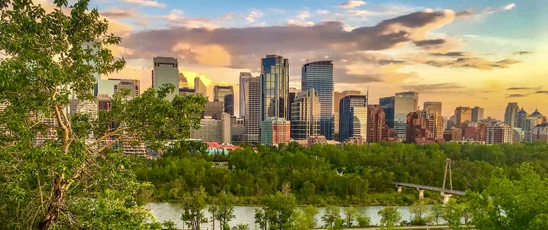 Photo de l'horizon d'une ville à travers une rivière au coucher du soleil